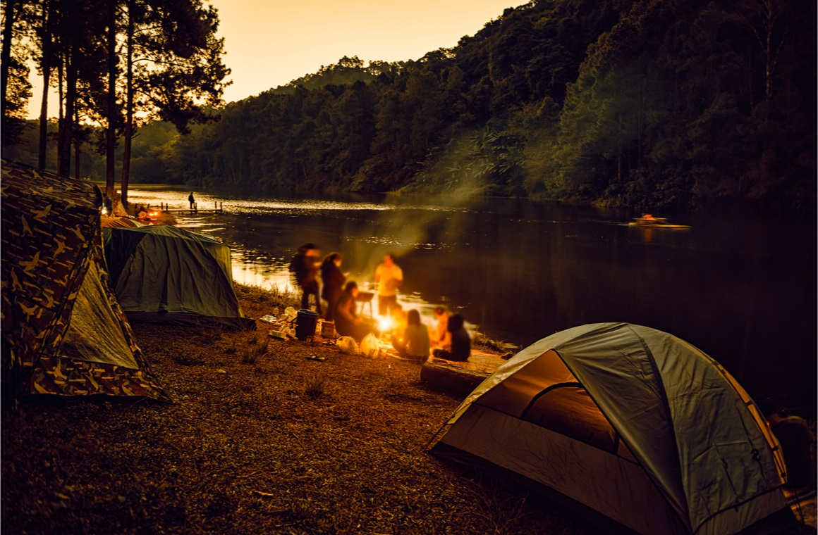 group of backpackers relaxing near campfire