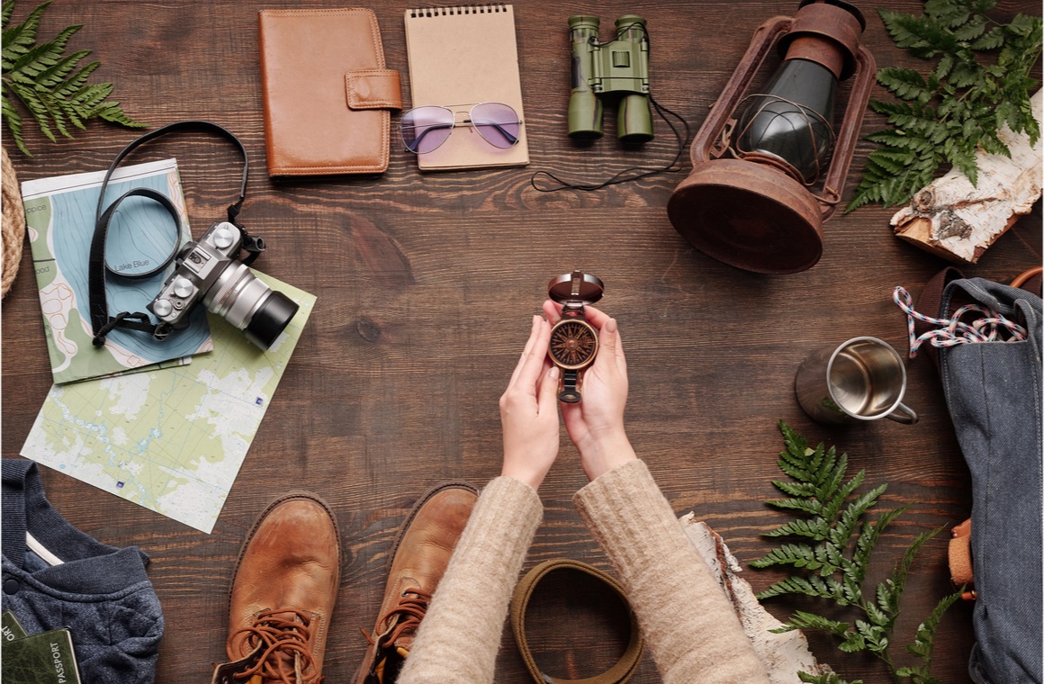 unrecognizable hiker in sweater holding open compass