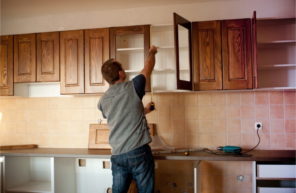 man working with new kitchen cabinets