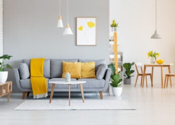 orange blanket on grey sofa in modern apartment