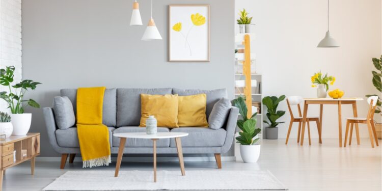 orange blanket on grey sofa in modern apartment