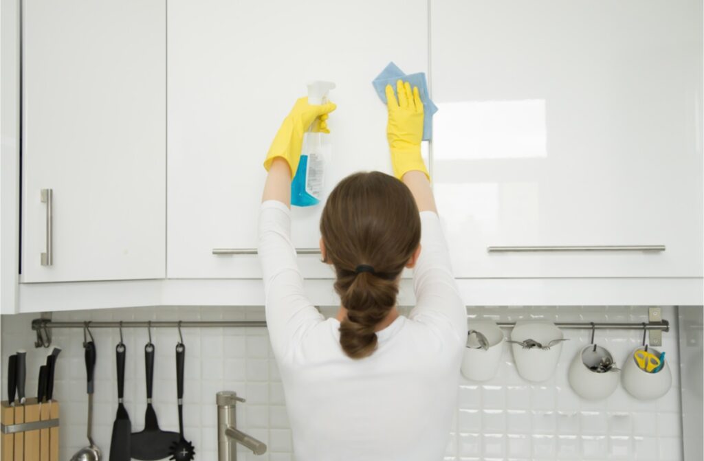 woman cleaning kitchen doors