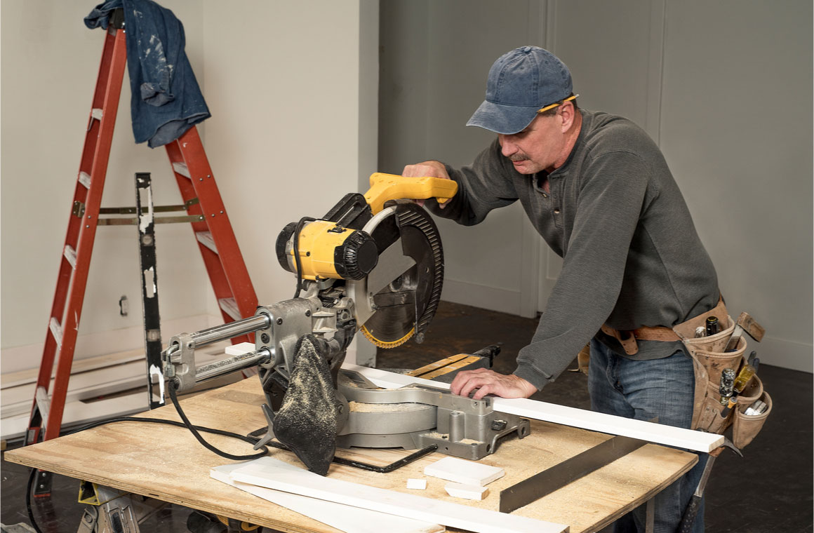 male carpenter cutting wood