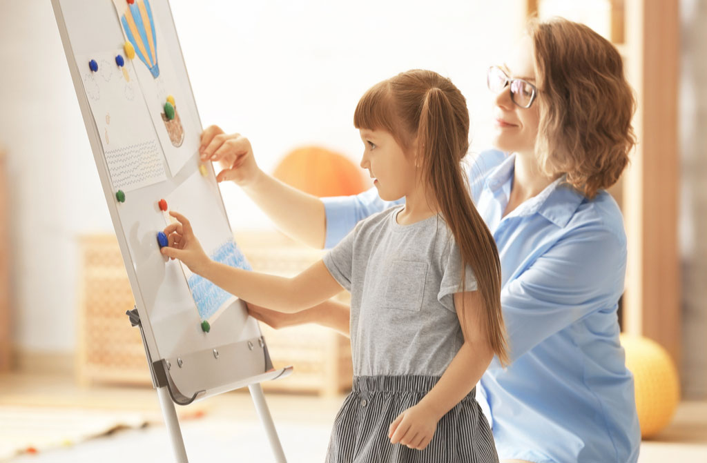 female psychologist painting with little girl