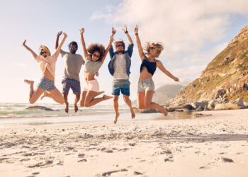 group of friends together on the beach living
