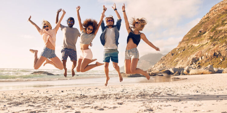 group of friends together on the beach living