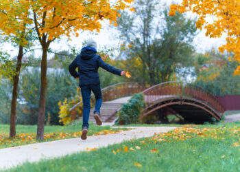 girl walks along path enjoys autumn