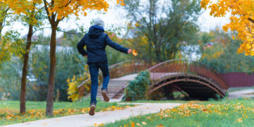 girl walks along path enjoys autumn