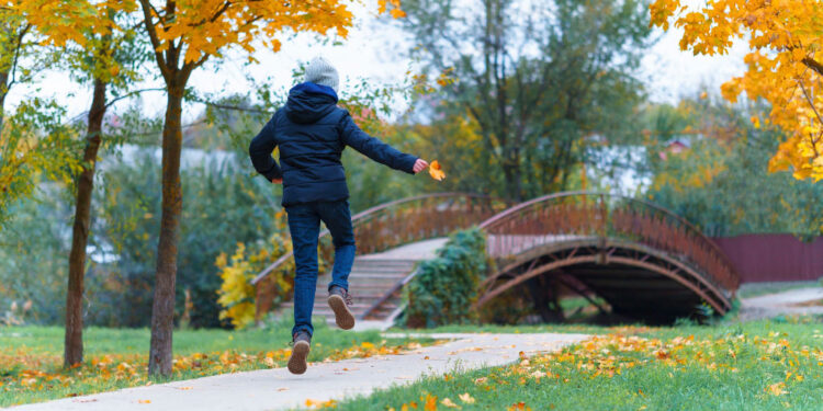 girl walks along path enjoys autumn