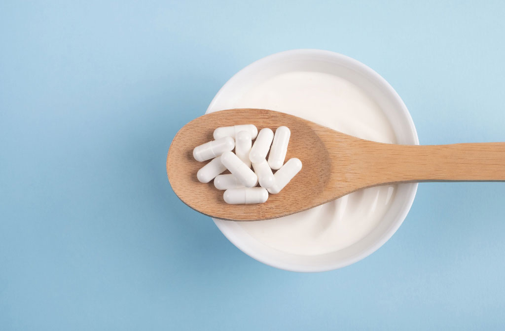 capsule probiotics on wooden spoon