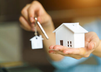 woman holding white house model key