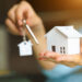 woman holding white house model key