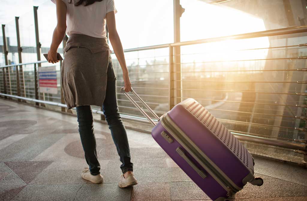 young woman pulling suitcase in airport