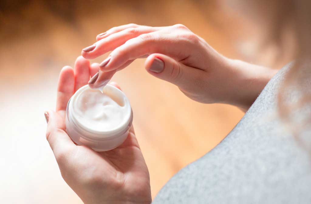 young woman uses body care cream