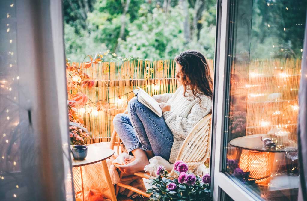 woman relaxing on cozy balcony