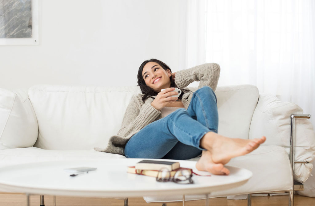 smiling woman resting on sofa