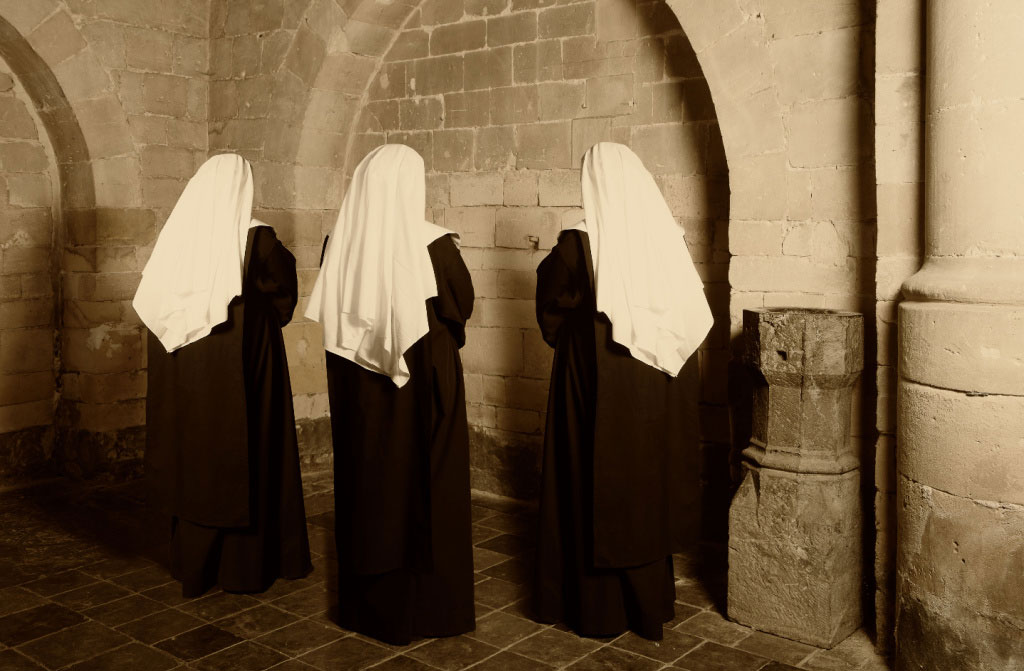 three nuns habit standing medieval abbey