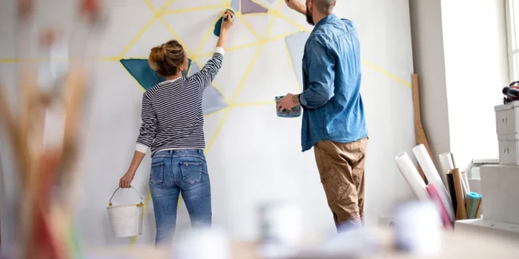 couple painting wall indoors