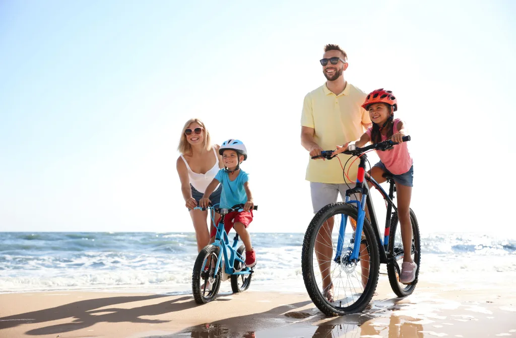 happy parents teaching kids running bikes