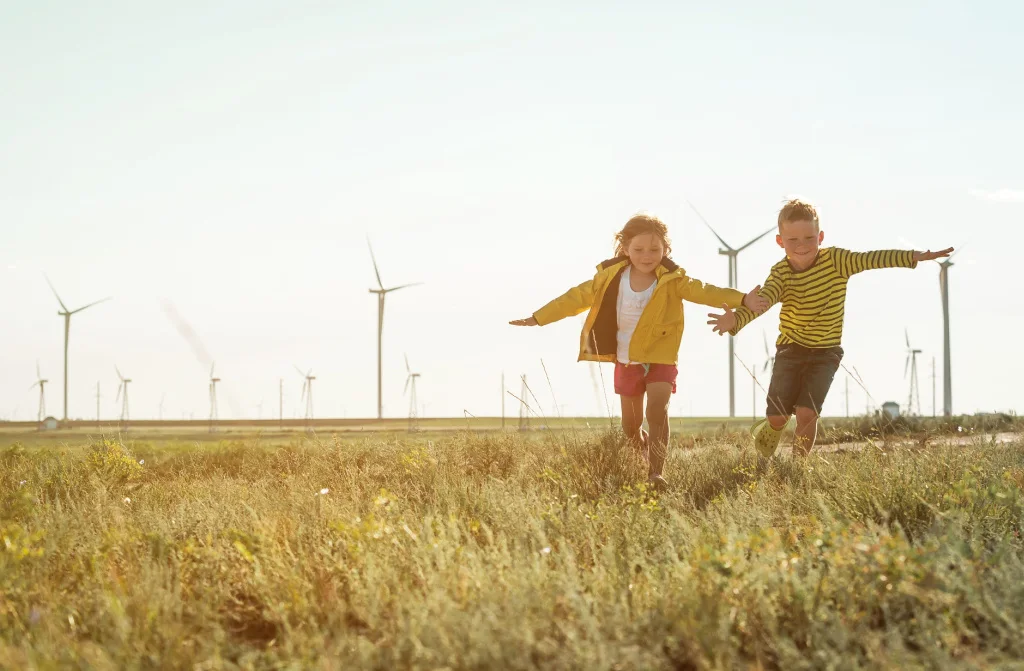 little boy running front windmills